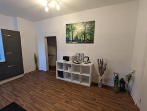 Zimmer mit einem weißen Schrank und einem Gemälde an der Wand in der Unterkunft Cityhouse - Wiesen in Wuppertal