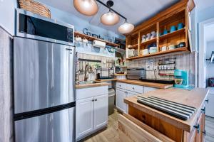 a kitchen with white cabinets and a stainless steel refrigerator at Dog-Friendly Beach Apt with Private Yard! in Jacksonville Beach