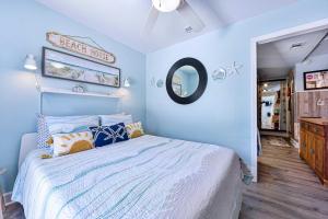 a blue bedroom with a bed and a mirror at Dog-Friendly Jacksonville Beach Apt near Beach in Jacksonville Beach