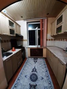 una pequeña cocina con fregadero y ventana en Apartment for guests in the centre of Tashkent city en Tashkent