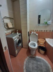 a bathroom with a toilet and a washing machine at Apartment for guests in the centre of Tashkent city in Tashkent