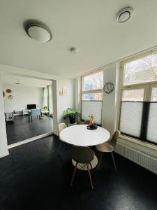 una oficina con una mesa blanca, sillas y ventanas en Aparthotel Le Provence, en Sneek