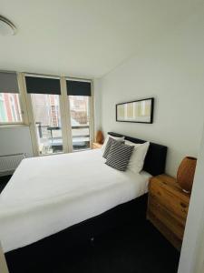 a large white bed in a room with windows at Aparthotel Le Provence in Sneek