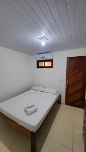 a bed in a room with a ceiling at Aloha Suites in Barra de São Miguel