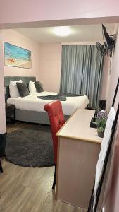 um quarto de hotel com 2 camas e uma secretária com uma secretária em Hotel L'Empire em Olm