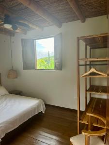 1 dormitorio con cama y ventana en Hacienda La Mesa - Coffee farm, en La Paloma