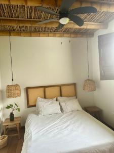 1 dormitorio con 1 cama blanca y ventilador de techo en Hacienda La Mesa - Coffee farm, en La Paloma