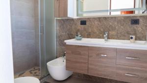 a bathroom with a toilet and a sink and a shower at La Cinta 2 in San Teodoro +12 photos