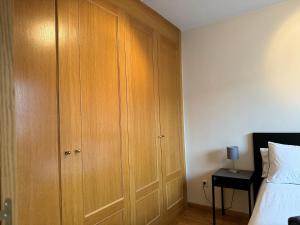 1 dormitorio con armario de madera junto a la cama en Chalet IFema 5 Habitaciones 4 baños, parking free en Madrid