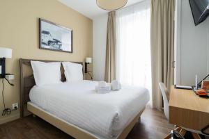 a hotel room with a bed and a desk with a computer at Best Western Hotel De La Plage Saint Marc sur Mer in Saint-Nazaire