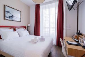 1 dormitorio con 1 cama y escritorio con ordenador en Best Western Hotel De La Plage Saint Marc sur Mer, en Saint-Nazaire