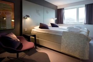 a bedroom with a bed with a window and a chair at Scandic S:t Jörgen in Malmö