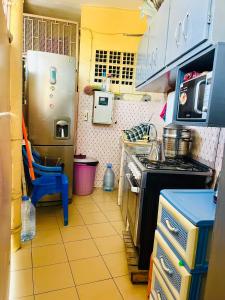 a small kitchen with a stove and a refrigerator at Studio meublé à fann hock in Dakar