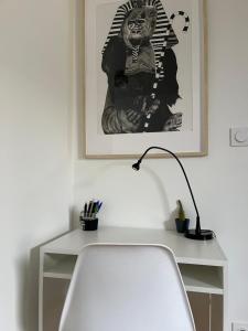 a desk with a white chair and a lamp at Appartement Cosy et Confortable in Saint-Genis-Laval