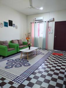 ein Wohnzimmer mit einem Sofa und einem Tisch in der Unterkunft Santai HomeStay Sipitang in Sipitang