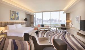 دبل تري باي هيلتون في الدوحة: غرفة فندقية بسرير ونافذة كبيرة
