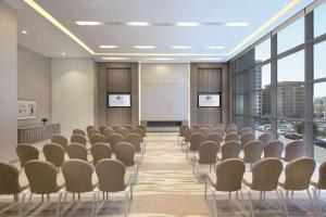 a conference room with chairs and a whiteboard at DoubleTree by Hilton Doha Old Town in Doha