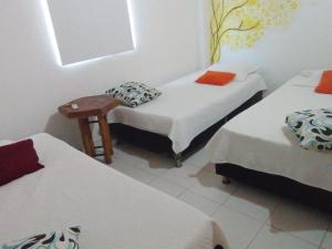 ein Zimmer mit 2 Betten und einem Stuhl darin in der Unterkunft HOTEL SANTA VERONICA INN in Santa Veronica