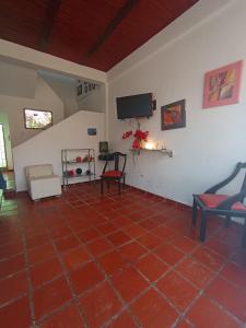 sala de estar con suelo de baldosa roja y TV en HOTEL SANTA VERONICA INN, en Santa Verónica