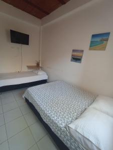 Schlafzimmer mit einem Bett und einem Flachbild-TV in der Unterkunft HOTEL SANTA VERONICA INN in Santa Veronica