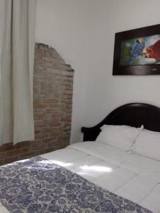 a bedroom with a bed and a brick wall at CASONA ALBARELO in Puebla