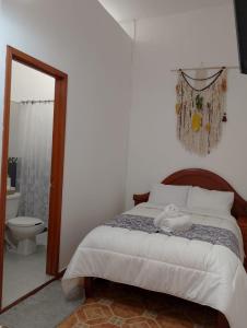 a bedroom with a bed and a bathroom with a toilet at CASONA ALBARELO in Puebla