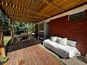 a bedroom on a deck with a bed on a patio at Benirras Beach House in Balneario Sauce Grande