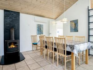 comedor con mesa y chimenea en Four-Bedroom Holiday home in Løkken 28, en Lønstrup