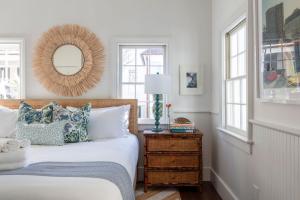 Schlafzimmer mit einem Bett, einem Spiegel und Fenstern in der Unterkunft Blue Cottage at Casa Zoe in Charleston + 26 Fotos