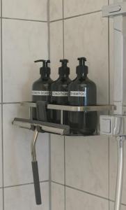 a shelf in a bathroom with three bottles on it at Ferienwohnung Hüppelröttchen in Eitorf
