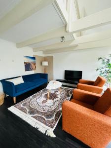 a living room with two chairs and a blue couch at Aparthotel Le Provence in Sneek