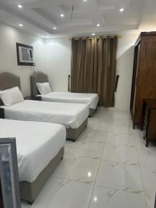 a hotel room with two beds and a television at العمري للشقق المفروشة الشهرية in Medina
