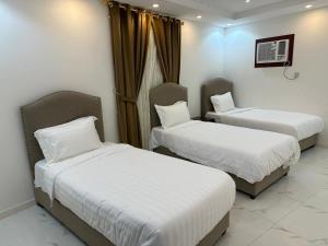 a room with two beds and a window at العمري للشقق المفروشة الشهرية in Al Madinah