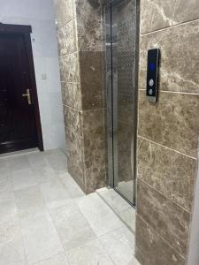 a shower with a glass door in a bathroom at العمري للشقق المفروشة الشهرية in Medina