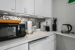 a kitchen with a microwave on a counter at Tropicals of Palm Beach in Palm Beach