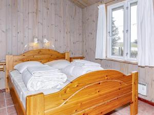 uma grande cama de madeira num quarto com uma janela em Holiday home Thisted LIX em Thisted