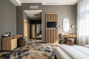 a bedroom with a bed and a sink and a mirror at URBAN HOTEL in Debrecen