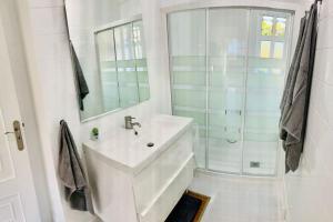 een witte badkamer met een wastafel en een douche bij La Brisa in Porto do Son