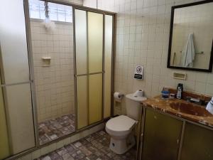 a bathroom with a toilet and a shower and a sink at Casa Vacacional Andy in Cali +97 photos
