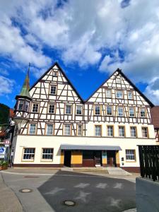 un grand bâtiment blanc avec une flèche dans une rue dans l'établissement Zur Schönen Lau- Monteurzimmer, à Blaubeuren