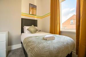 a small bedroom with a bed with a window at HugeDiscounts Monthly offers in Gateshead
