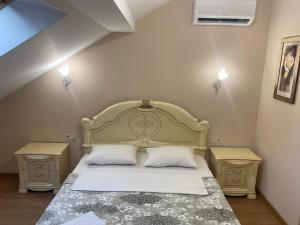 a bedroom with a bed and two night stands at Apart Yaroslava Osmomysla 9 Square - city center in Lviv
