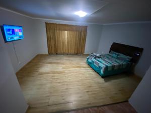 MOMENTS Of JOY GUESTHOUSE AND SPA AT CARNIVAL في Brakpan: غرفه فيها سرير وتلفزيون