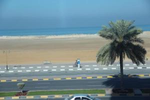 een motorrijder op een weg bij een strand bij Bareen Hotel in Ajman 