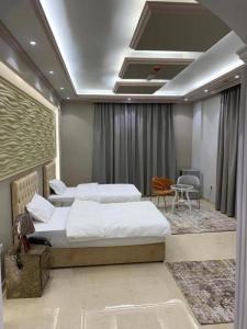een slaapkamer met 2 bedden en een tafel en stoelen bij Bareen Hotel in Ajman 