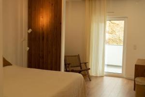 1 dormitorio con 1 cama, 1 silla y 1 ventana en Casa Aga- Cozy Seaside Apartment en Ericeira