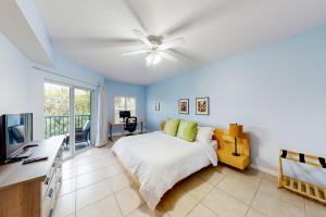 a bedroom with a bed and a ceiling fan at Oceanwalk 10-203 in New Smyrna Beach