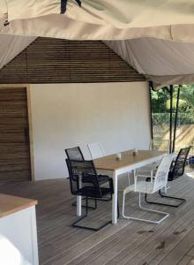 a table and chairs on a deck with an umbrella at Two bedroom tent on the beach private plunge pool in Matapalo