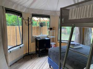 1 dormitorio con cama y lavamanos en una tienda de campaña en Two bedroom tent on the beach private plunge pool, en Matapalo