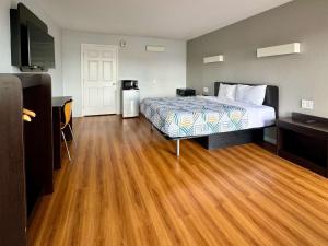 ein Hotelzimmer mit einem Bett und Holzboden in der Unterkunft Motel 6-Delano, CA in Delano